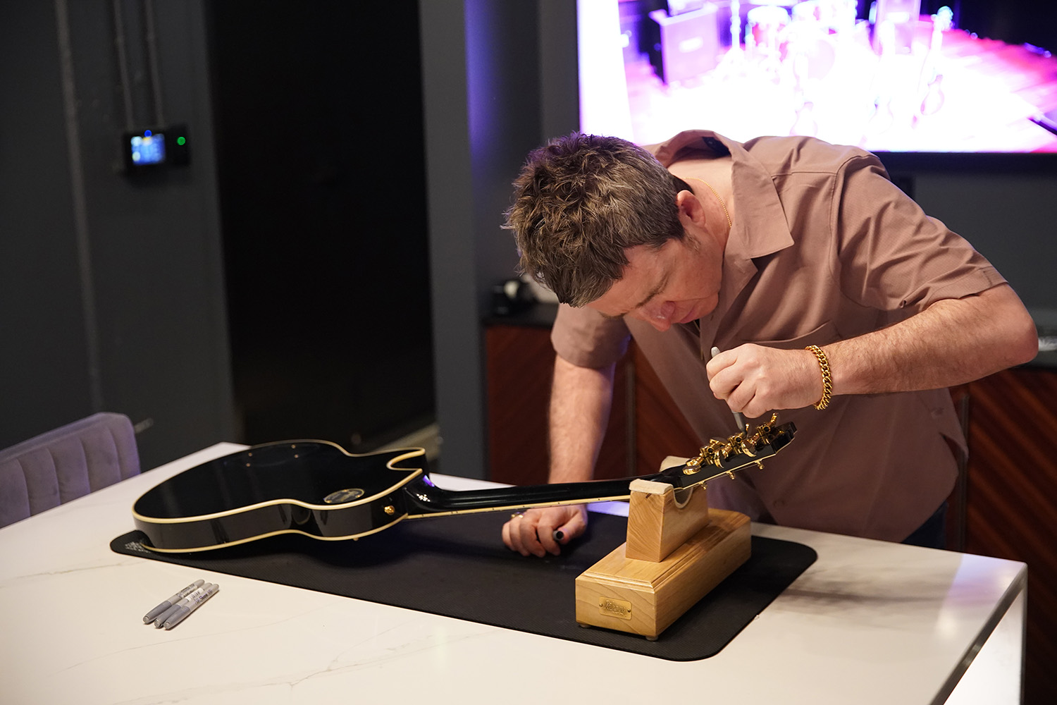 Noel Gallagher signing a '78 Les Paul Custom by Sharon Latham