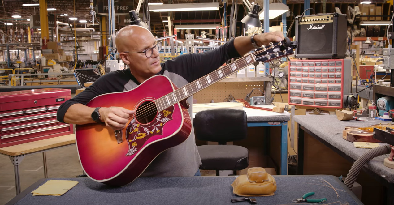 Jim DeCola restrings a Gibson Hummingbird acoustic guitar