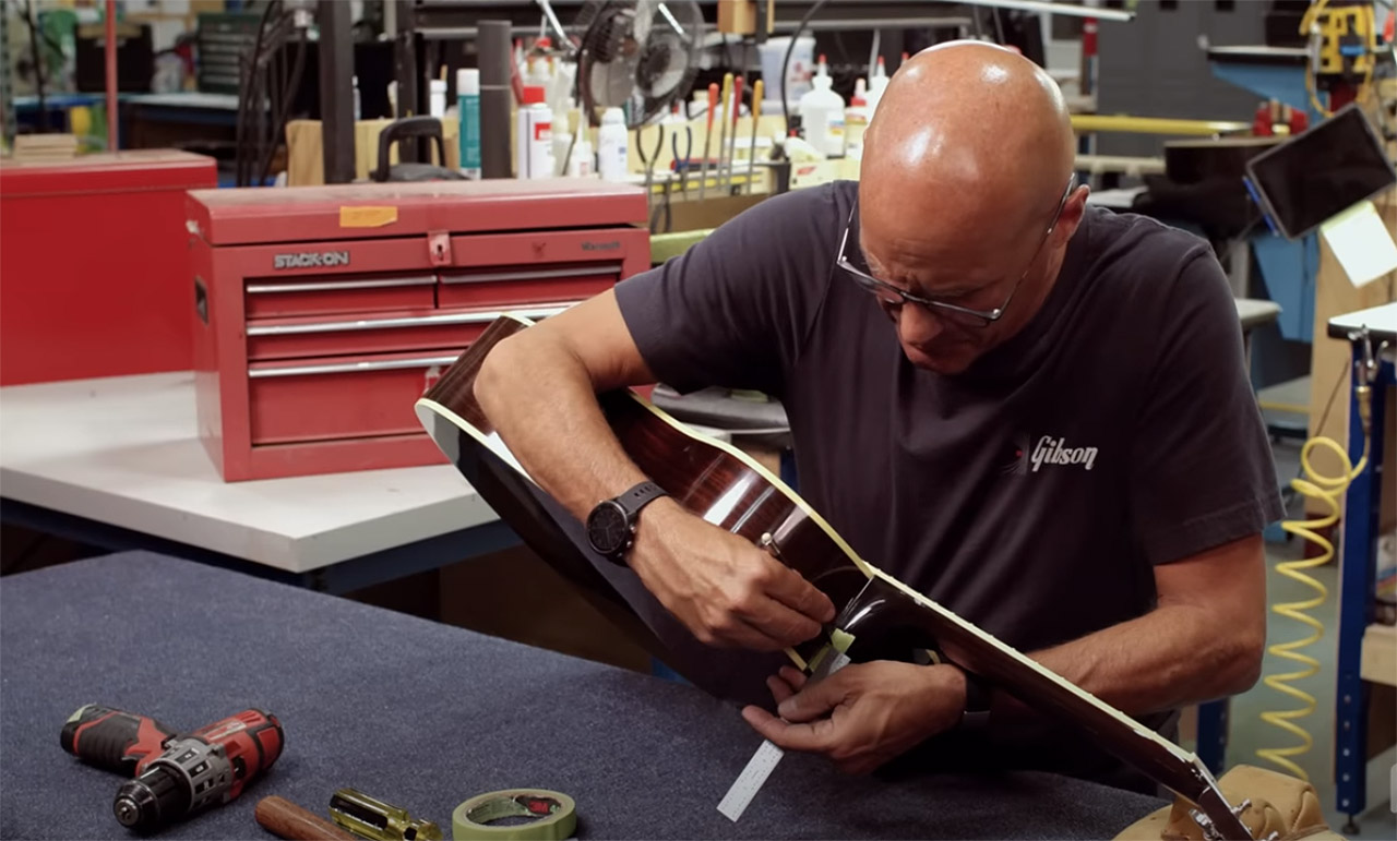 Jim DeCola installing a strap button on a Gibson acoustic guitar